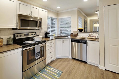 a kitchen with white cabinets and stainless steel appliances